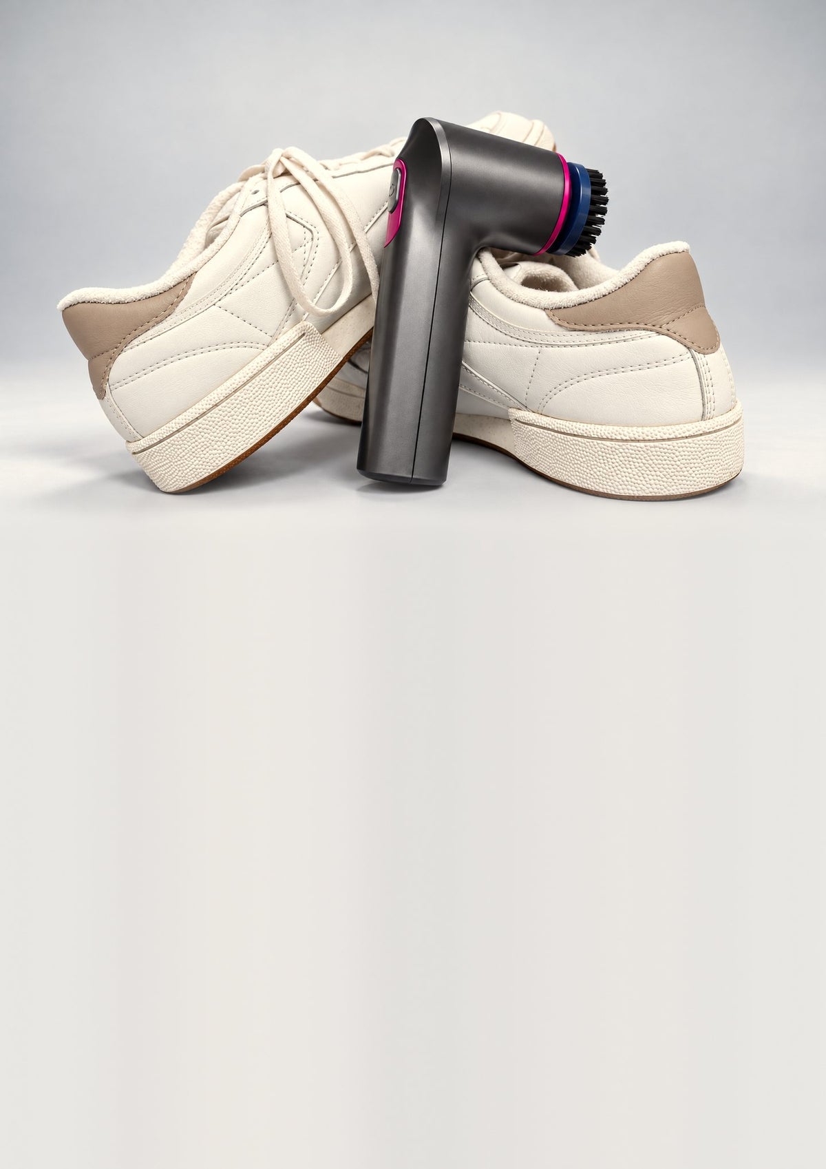 PUREKICKZ ONE Sneaker Cleaner lehnt an zwei hellen Sneakern